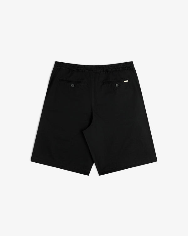 The Cotton Casual Short in black is shown from the back with two buttoned pockets and a right-side tag.
