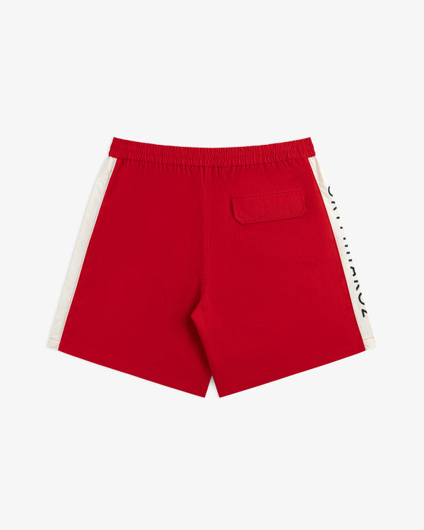 ALD / Olympiacos F.C. Nylon Training Short in red with white side panels and a back pocket.