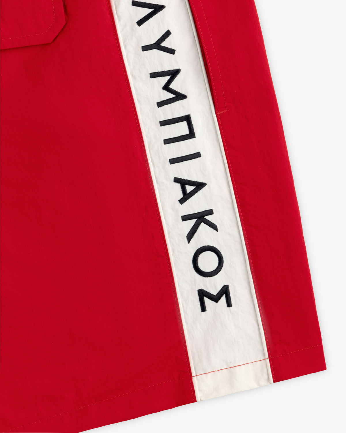 ALD / Olympiacos F.C. Nylon Training Short: red nylon shorts with a white side stripe featuring black Greek lettering.