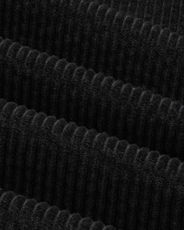 Close-up of the black corduroy fabric of the Corduroy Leon Overshirt with vertical ridges.