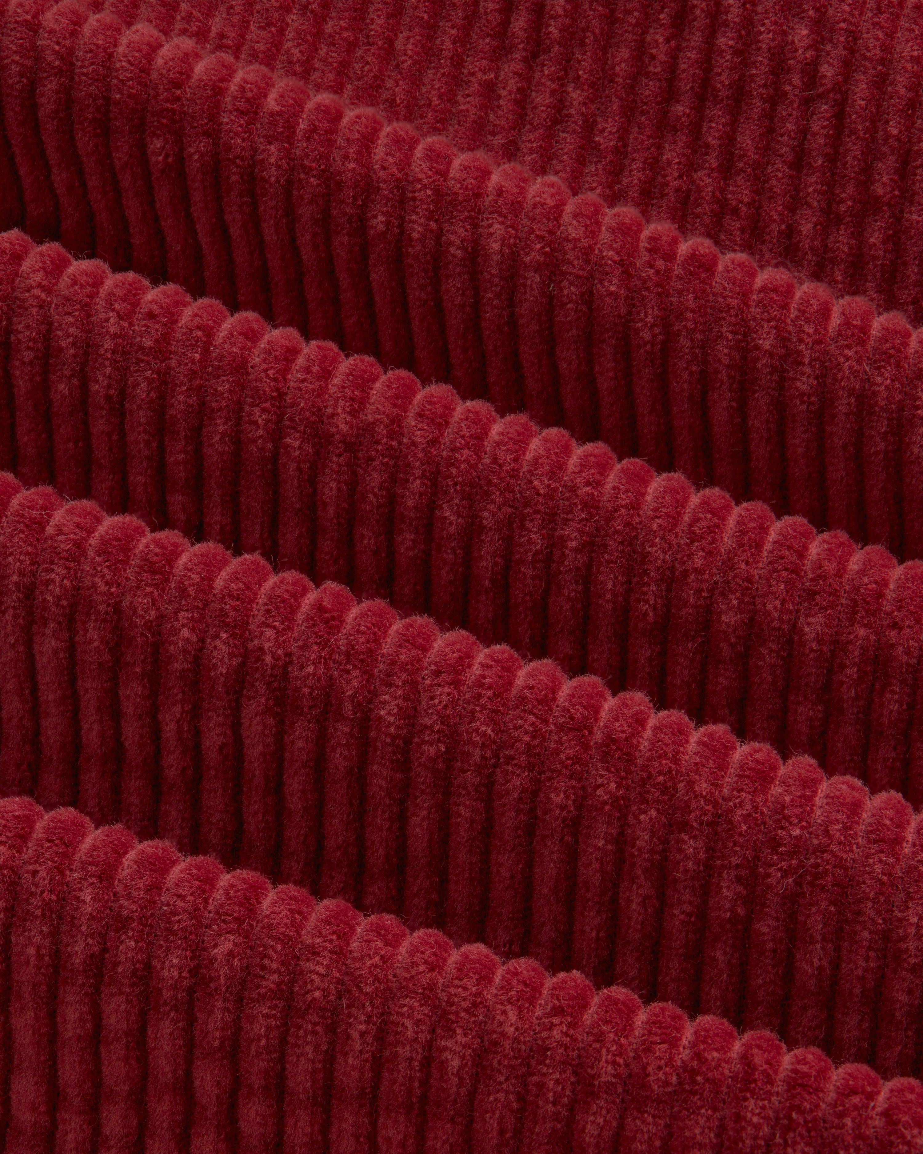 Close-up of deep red Corduroy Leon Overshirt fabric with raised vertical ridges.