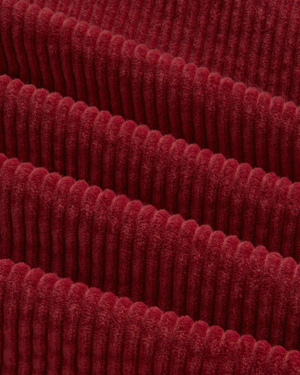 Close-up of deep red Corduroy Leon Overshirt fabric with raised vertical ridges.