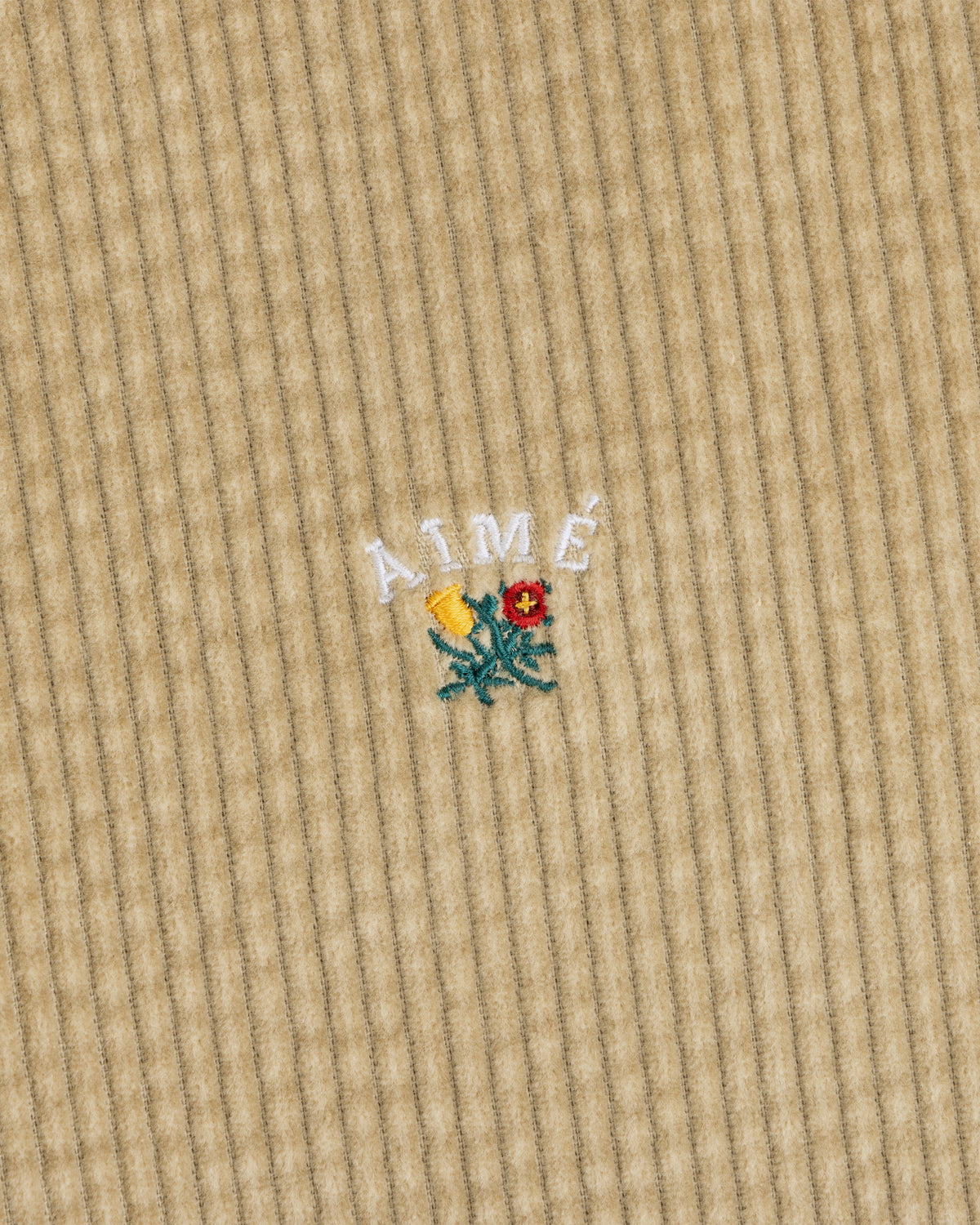 Corduroy Leon Overshirt in tan corduroy with white embroidered Aime text above a small floral design.