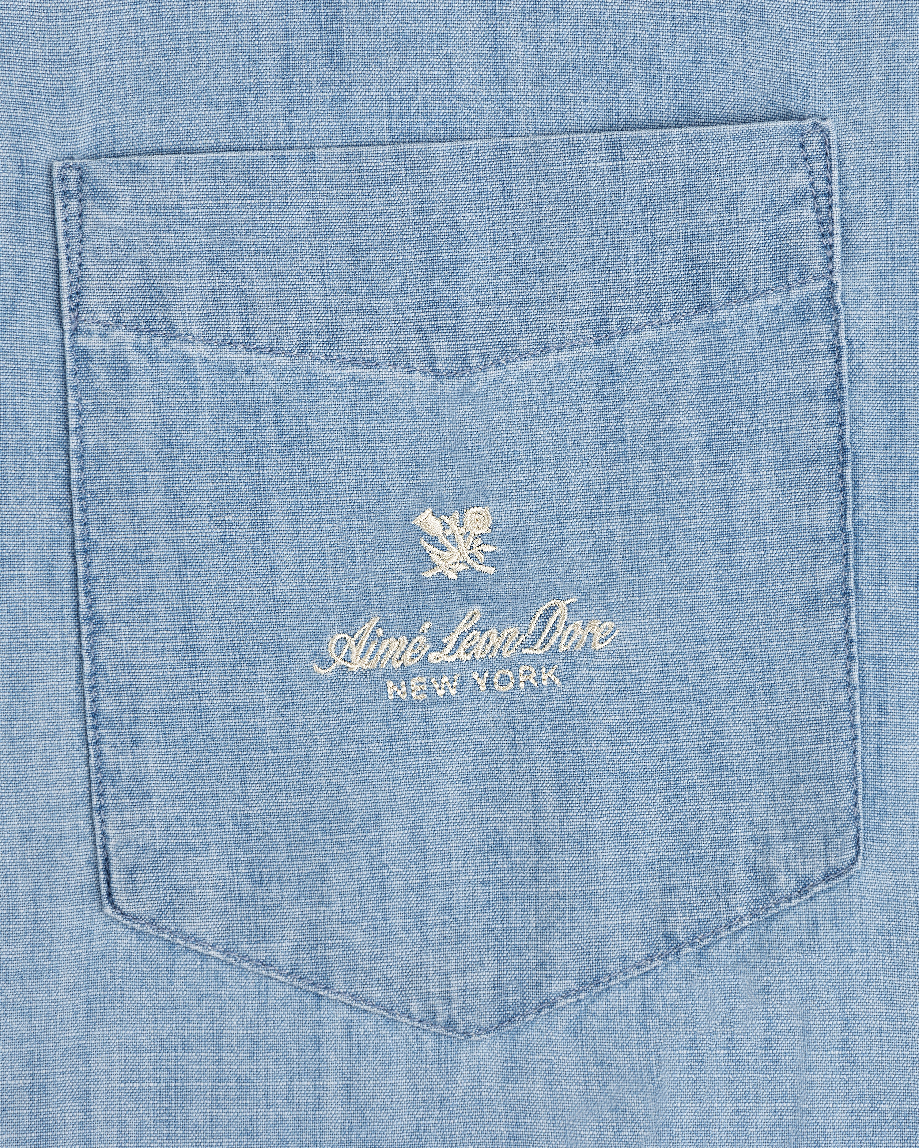 Bayard Chambray Shirt: Light blue pocket with embroidered Aimé Leon Dore New York and small floral logo above.