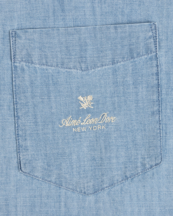 Bayard Chambray Shirt: Light blue pocket with embroidered Aimé Leon Dore New York and small floral logo above.