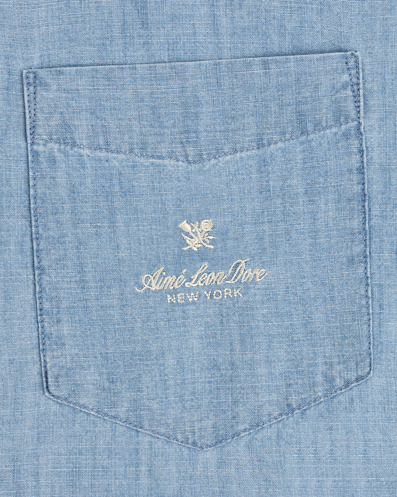 Bayard Chambray Shirt: Light blue pocket with embroidered Aimé Leon Dore New York and small floral logo above.