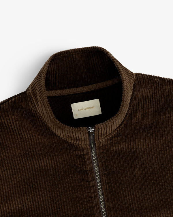 Close-up of a dark brown Quarter Zip Corduroy Shirt featuring a high collar and a branded inner neck label.