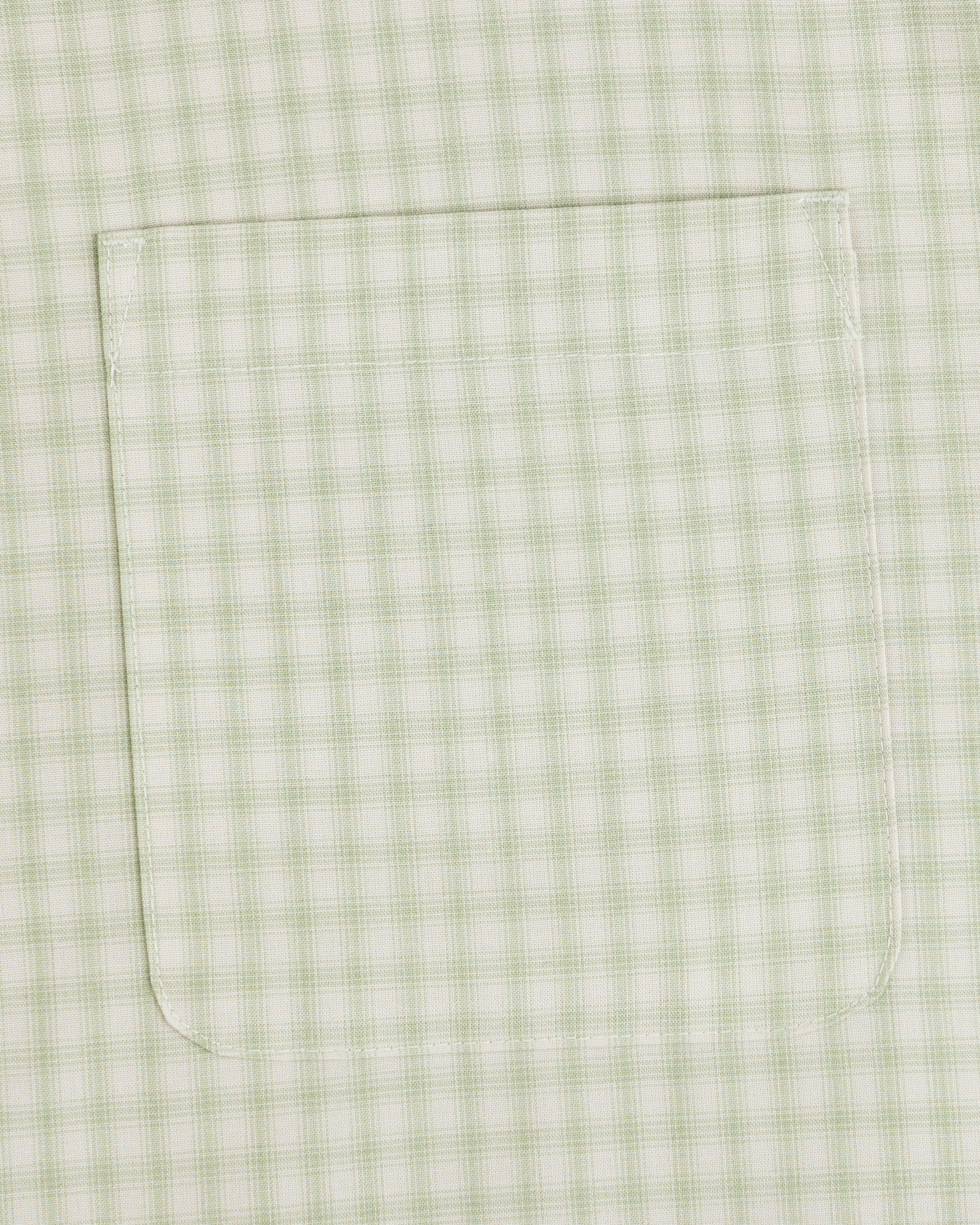 A close-up of the Plaid Casual Shirt’s light green and white pocket, featuring detailed visible stitching.