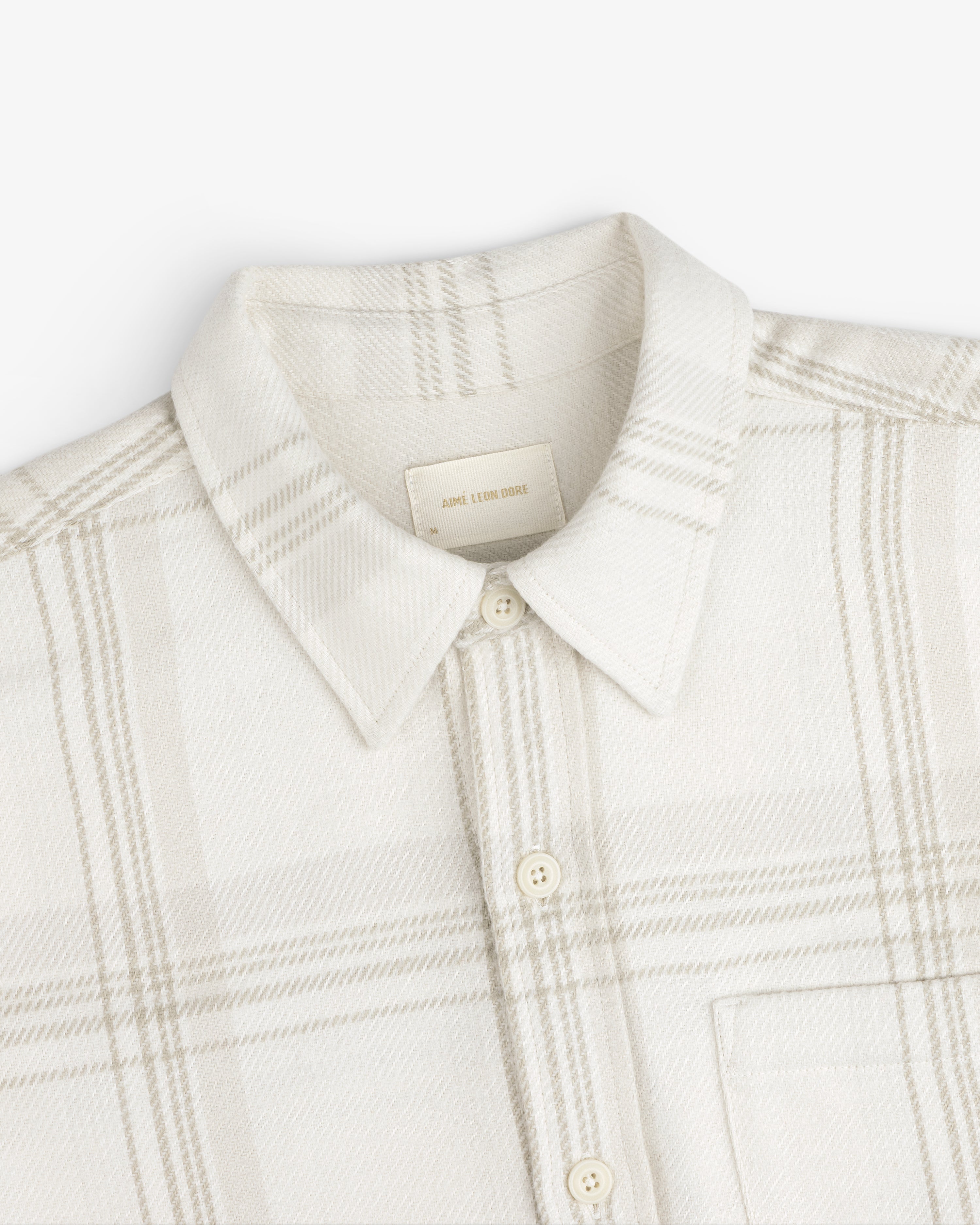 Yarn Dyed Plaid Overshirt: cream-colored long-sleeve button-up with a light brown plaid pattern and a pointed collar.