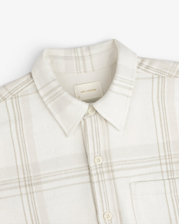 Yarn Dyed Plaid Overshirt: cream-colored long-sleeve button-up with a light brown plaid pattern and a pointed collar.