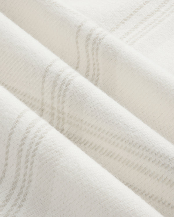 Yarn Dyed Plaid Overshirt in off-white fabric with a subtle, light gray plaid pattern and visible folds.