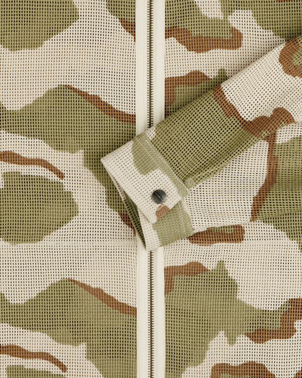 Close-up of a Camo Mesh Zip Overshirt featuring a camo-patterned mesh, zip-up closure, and a single button cuff.
