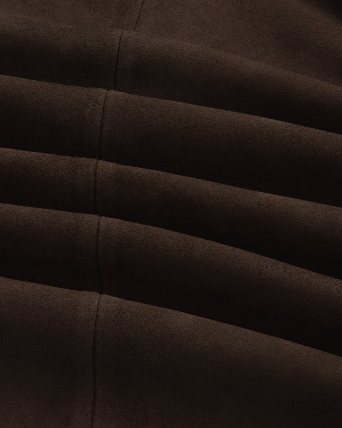 Close-up of the dark brown suede Suede Overshirt featuring horizontal seamed folds.