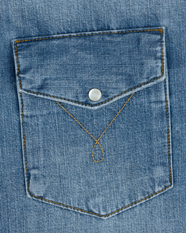 Blue denim chest pocket on a Denim Western Shirt with a pointed flap, silver snap button, and decorative gold stitching.