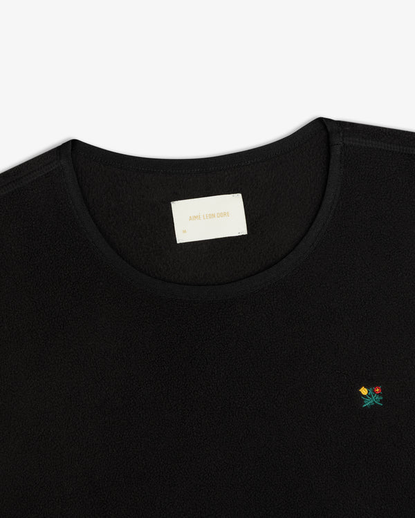 Black Crest Long-Sleeve Fleece Tee with a small flower embroidery and a branded neck label.