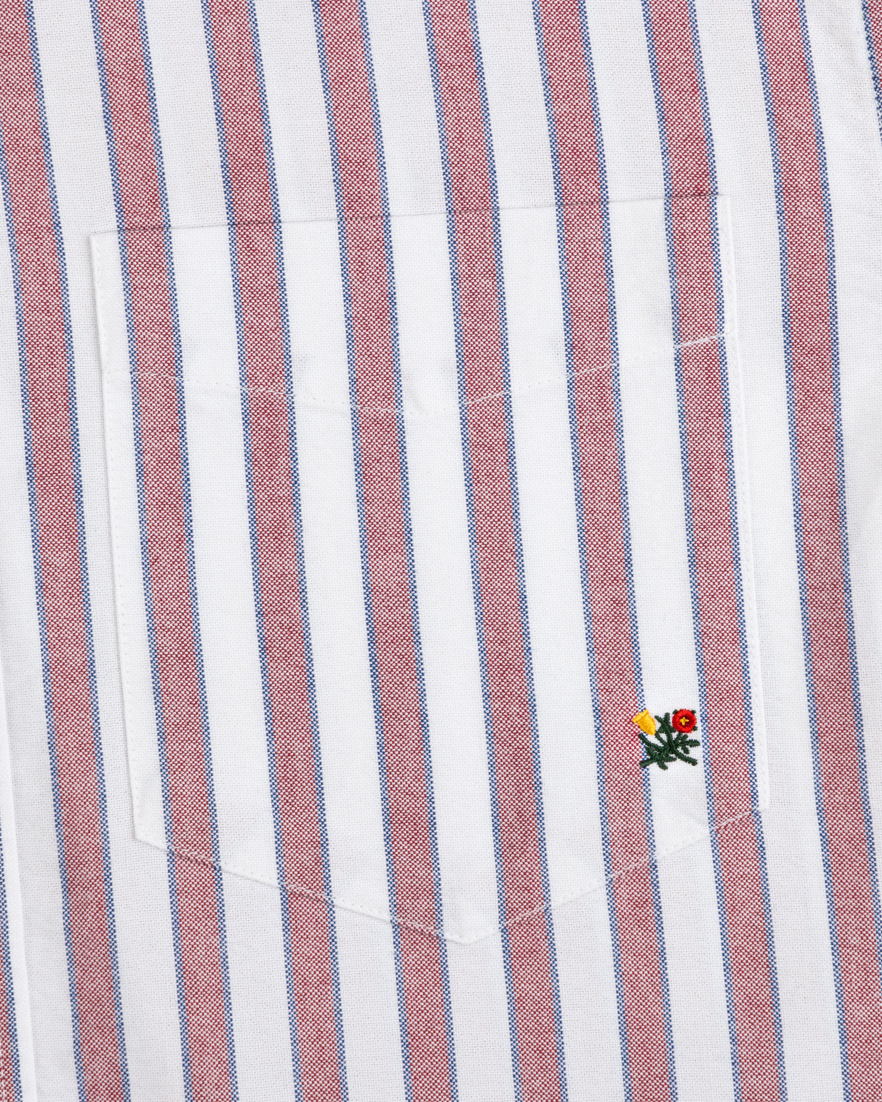 Striped Crest Oxford Shirt: White with red/blue stripes, chest pocket, and embroidered flowers at lower right.