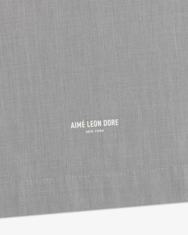 Close-up of gray Poplin Casual Shirt featuring small white Aimé Leon Dore New York text near the bottom center.