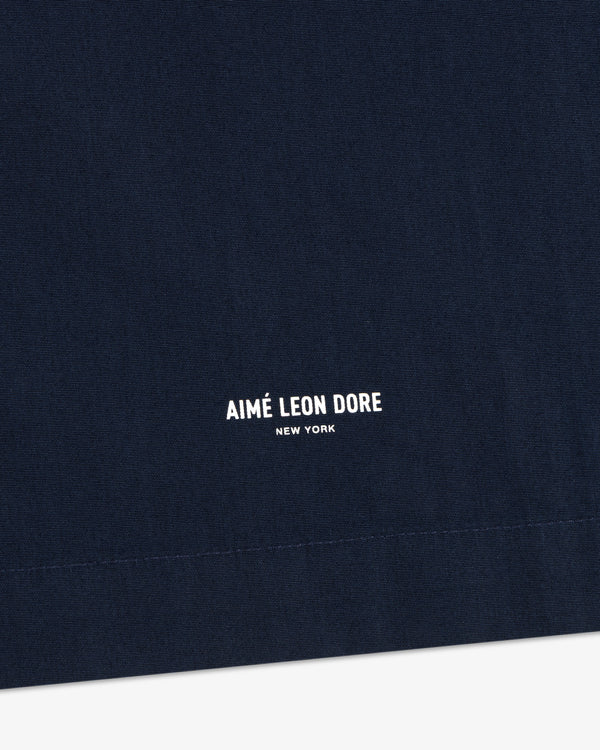 Close-up of navy Poplin Casual Shirt fabric with small white AIMÉ LEON DORE NEW YORK text centered at the bottom.