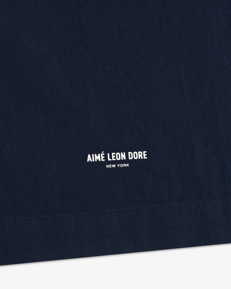 Close-up of navy Poplin Casual Shirt fabric with small white AIMÉ LEON DORE NEW YORK text centered at the bottom.