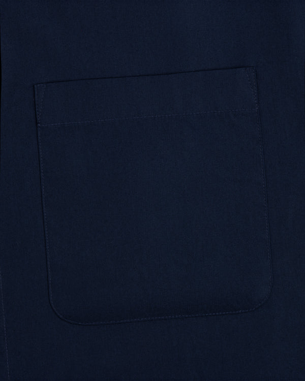 A close-up of a square, navy pocket sewn onto matching Poplin Casual Shirt fabric.