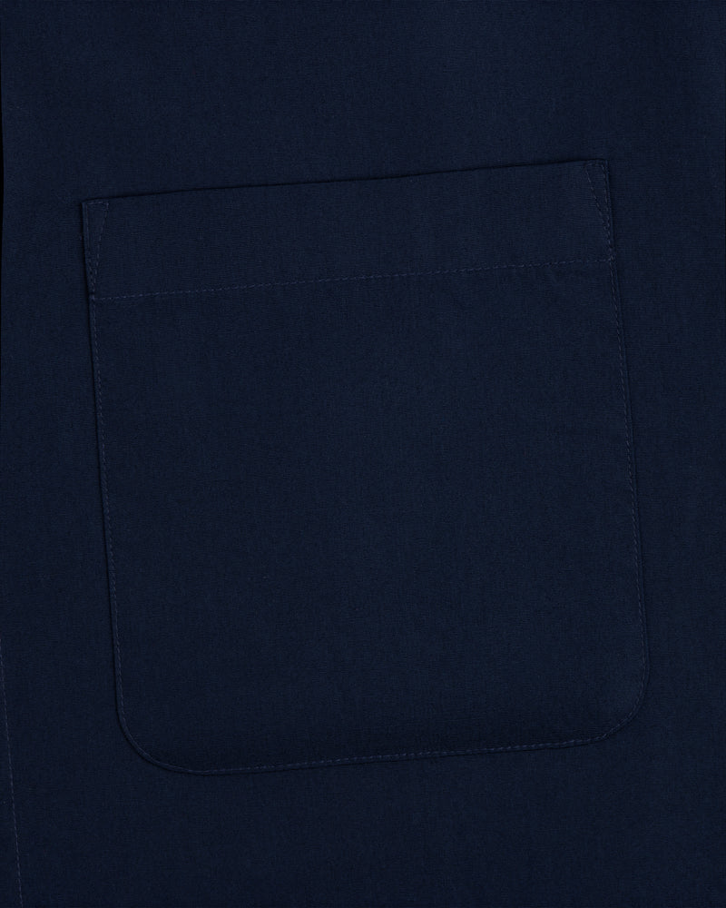 A close-up of a square, navy pocket sewn onto matching Poplin Casual Shirt fabric.