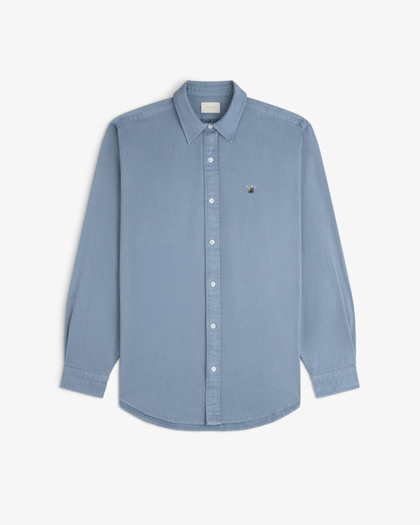 Garment Dyed Leon Overshirt in light blue, long sleeves, button-down, with embroidered crest on left chest.
