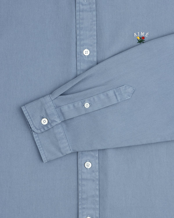 Garment Dyed Leon Overshirt: light blue, white buttons, small AIMÉ embroidery above the cuff.