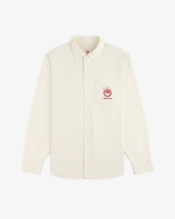 ALD / Olympiacos F.C. Logo Oxford Shirt: off-white long-sleeve button-down with a sports crest on the chest pocket.