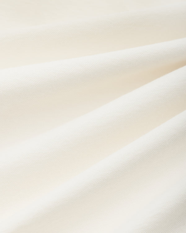 Close-up of off-white woven fabric with soft folds on an ALD / Olympiacos F.C. Logo Oxford Shirt.