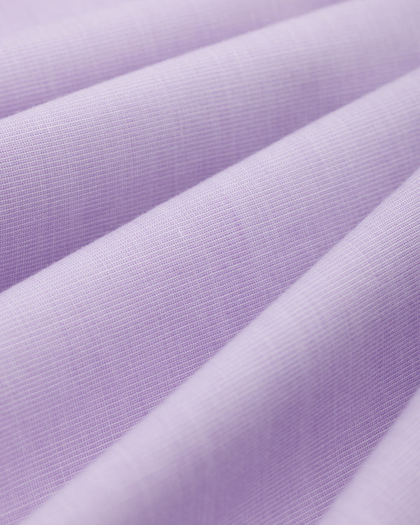 Close-up of light purple Button Down Poplin Shirt fabric with diagonal folds.