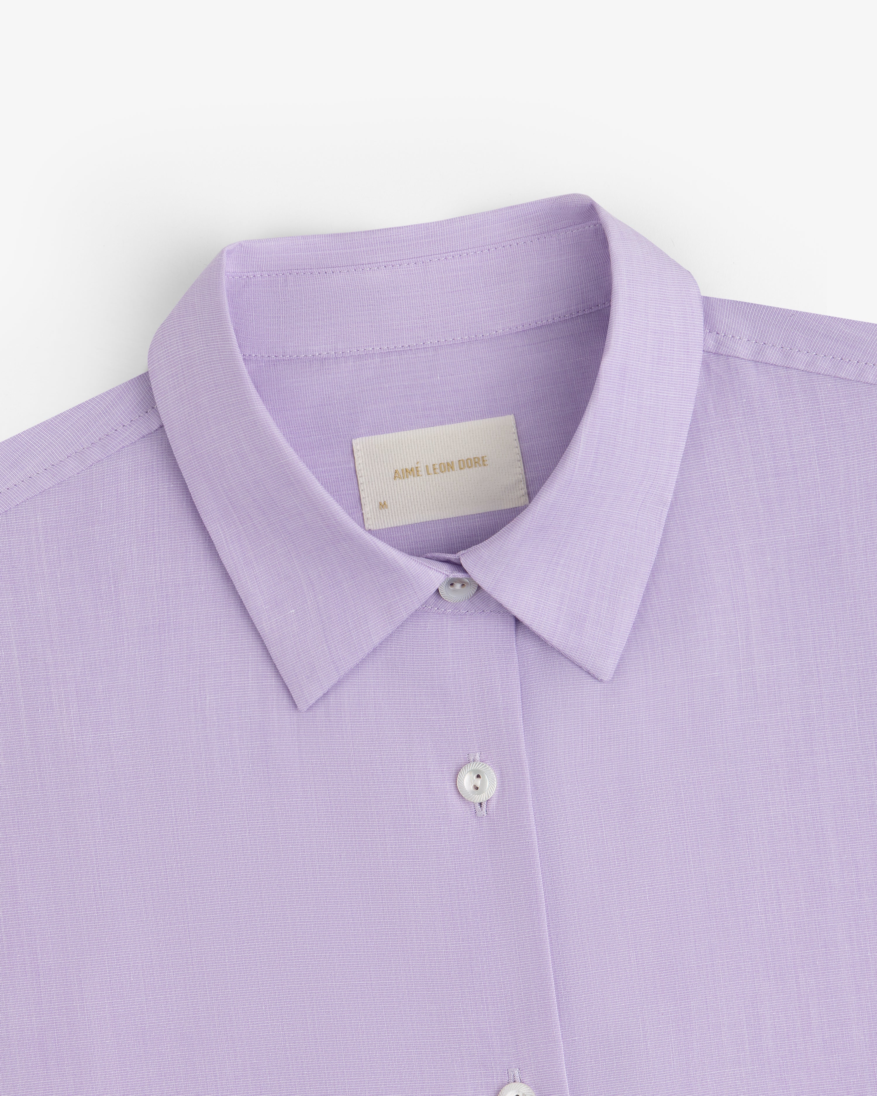 Close-up of a light purple Button Down Poplin Shirt with a collar and buttons.