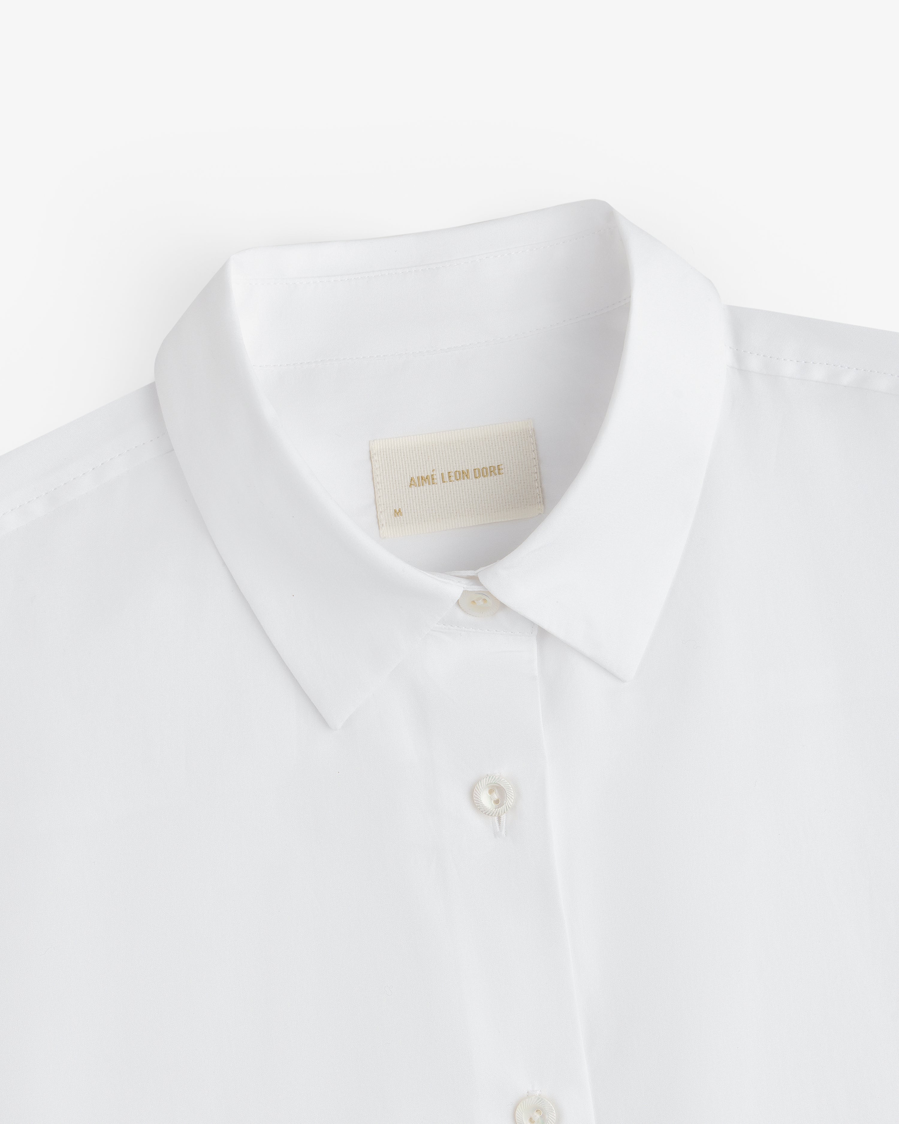White Button Down Poplin Shirt collar with a size medium tag at the neckline.