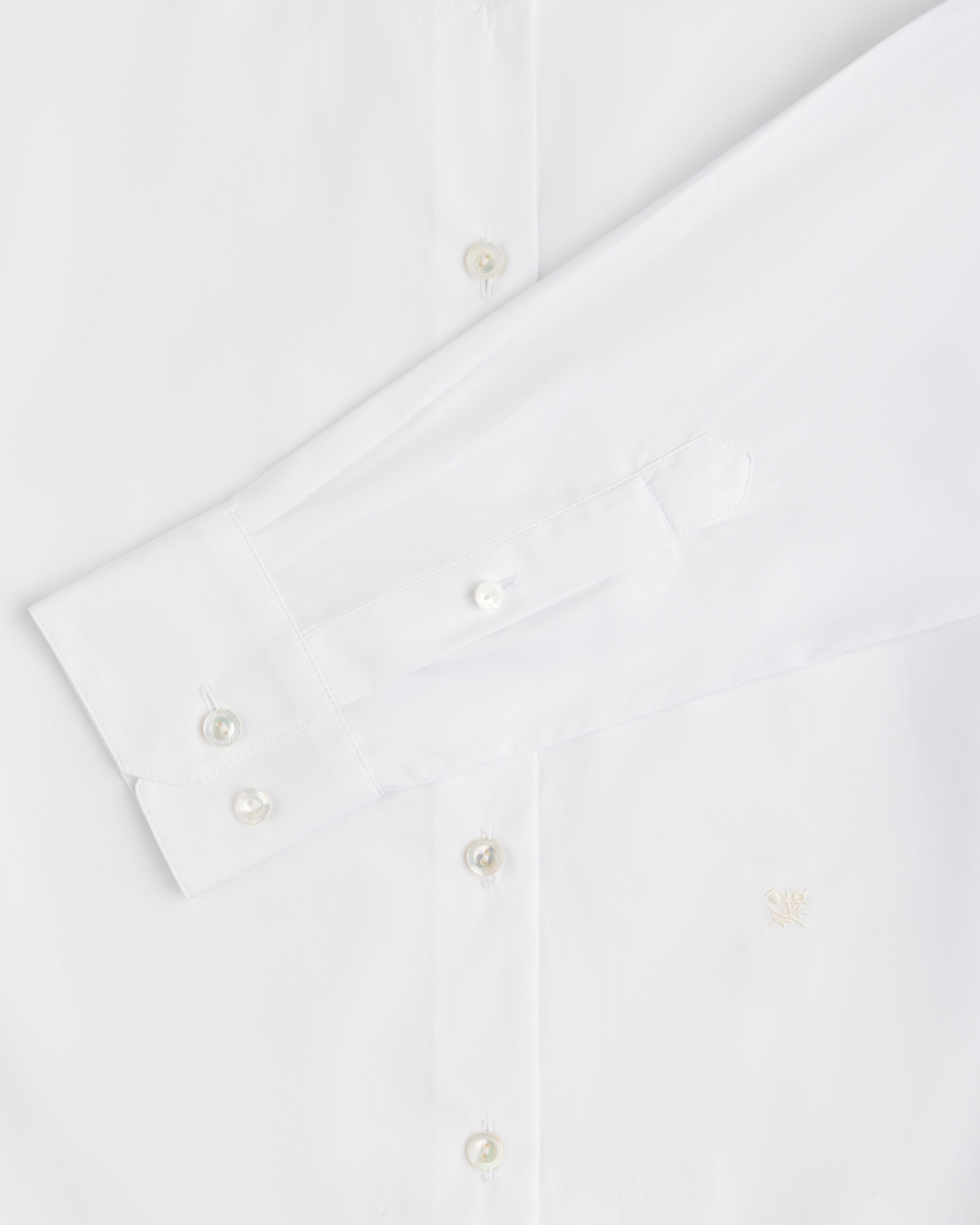 Close-up of a white Button Down Poplin Shirt featuring a barrel cuff with two buttons and a small embroidered logo.