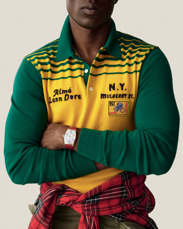 Man in green/yellow Merino Wool Knit Cycling Polo, arms crossed, red plaid shirt tied at waist.