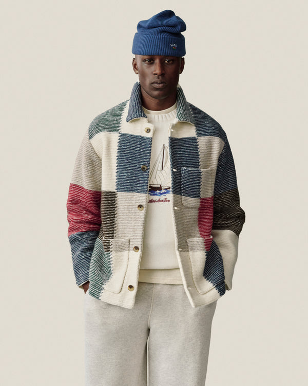 Man in a Regatta Embroidered Crewneck Sweater stands with hands in pockets against a neutral background.