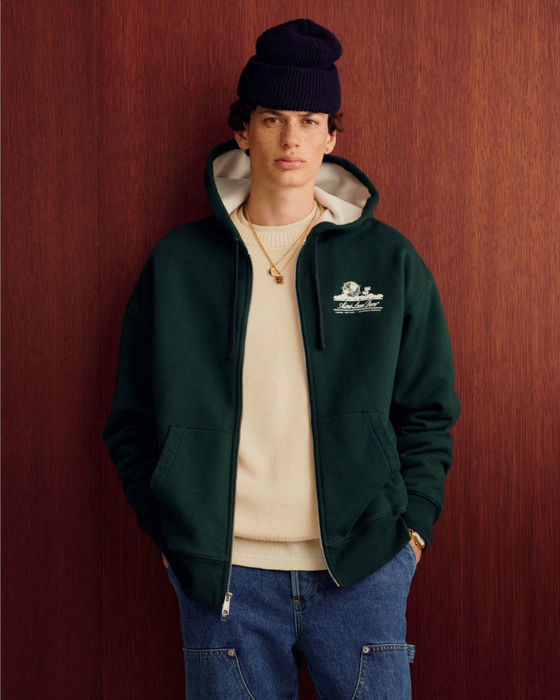 Someone wearing the Unisphere Waffle Lined Full-Zip Hoodie stands in front of a wood wall.