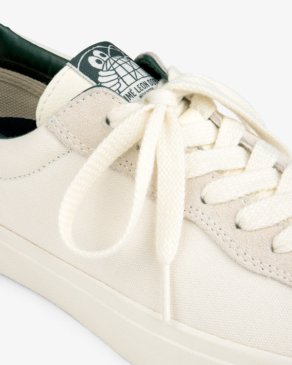 Close-up of the ALD / Last Resort AB VM001-LO Canvas sneaker with white laces and a green cartoon turtle tongue label.