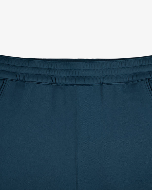 Front view close-up of ALD / New Balance RC56 Track Pant’s teal waistband and upper section with side pockets.