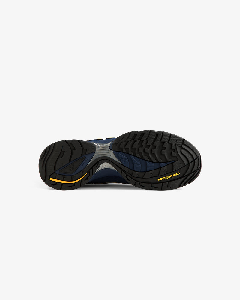 The image shows the black and navy sole of the ALD / New Balance RC56 sneaker with a yellow logo on white.