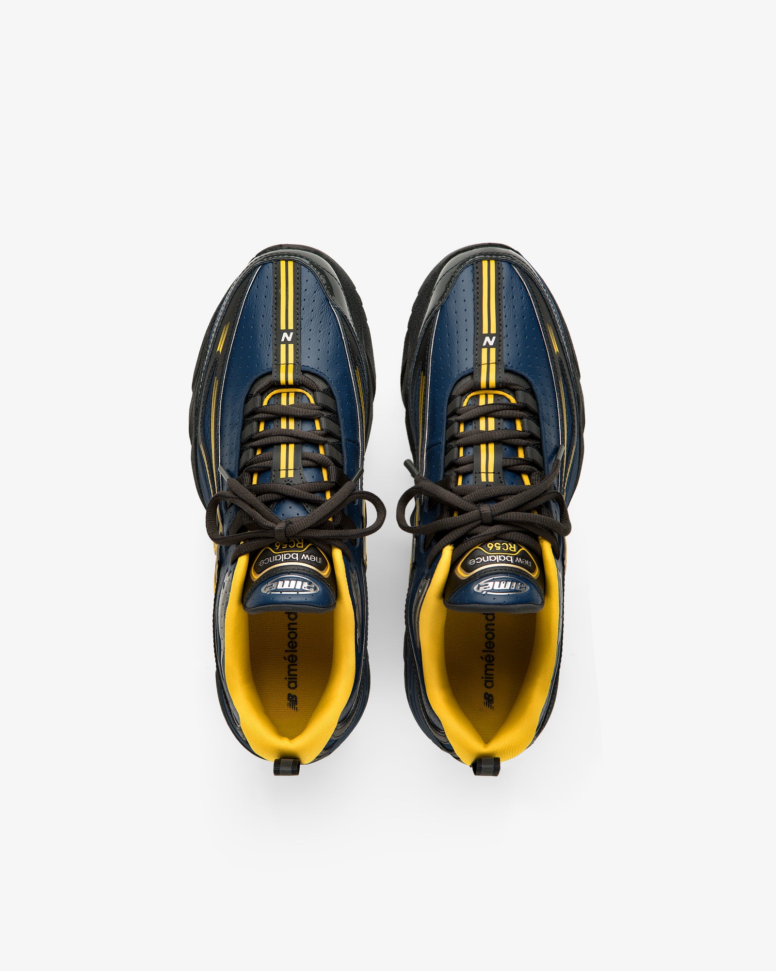 A pair of ALD / New Balance RC56 sneakers in blue, yellow, and black seen from above on a white background.