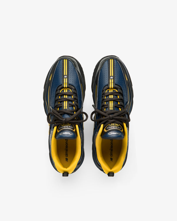 A pair of ALD / New Balance RC56 sneakers in blue, yellow, and black seen from above on a white background.