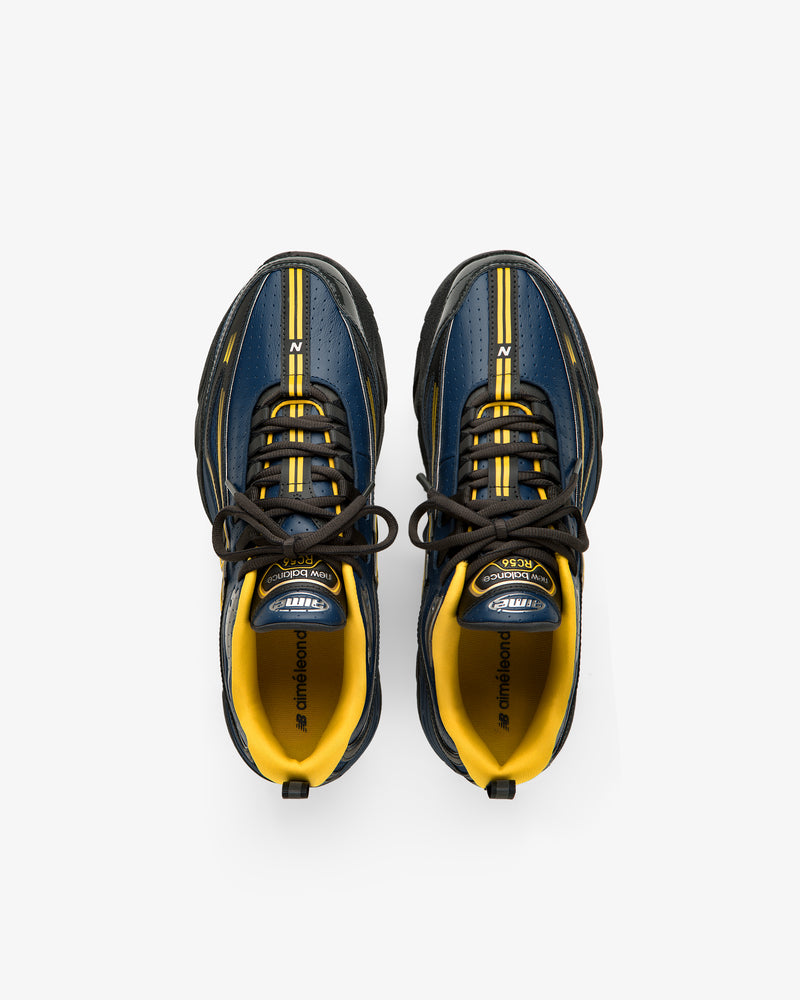 A pair of ALD / New Balance RC56 sneakers in blue, yellow, and black seen from above on a white background.