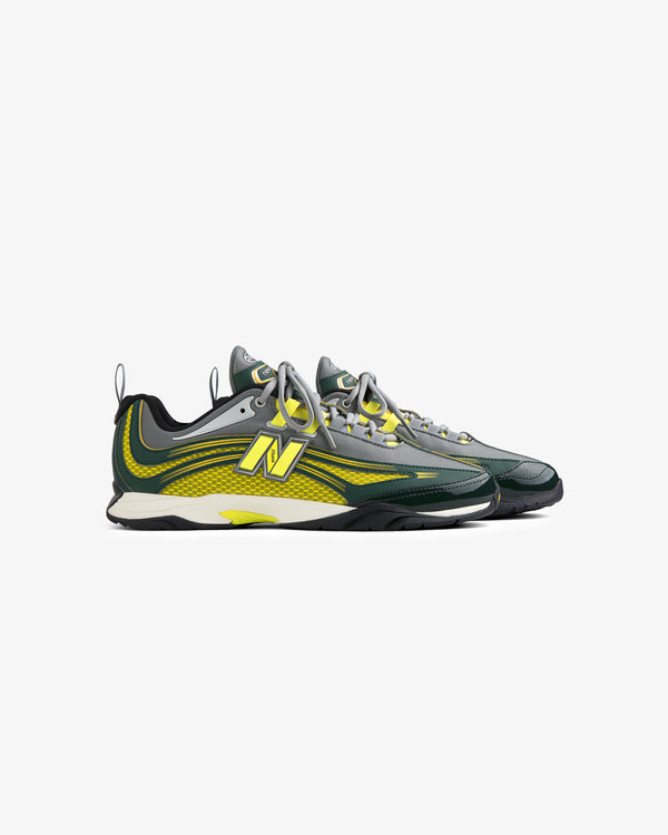 Two ALD / New Balance RC56 sneakers in gray, green, and yellow with mesh details, shown on a white background.
