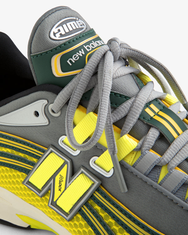 Close-up of the ALD / New Balance RC56 sneaker in gray, yellow, and green, highlighting laces, logo, and stitching.