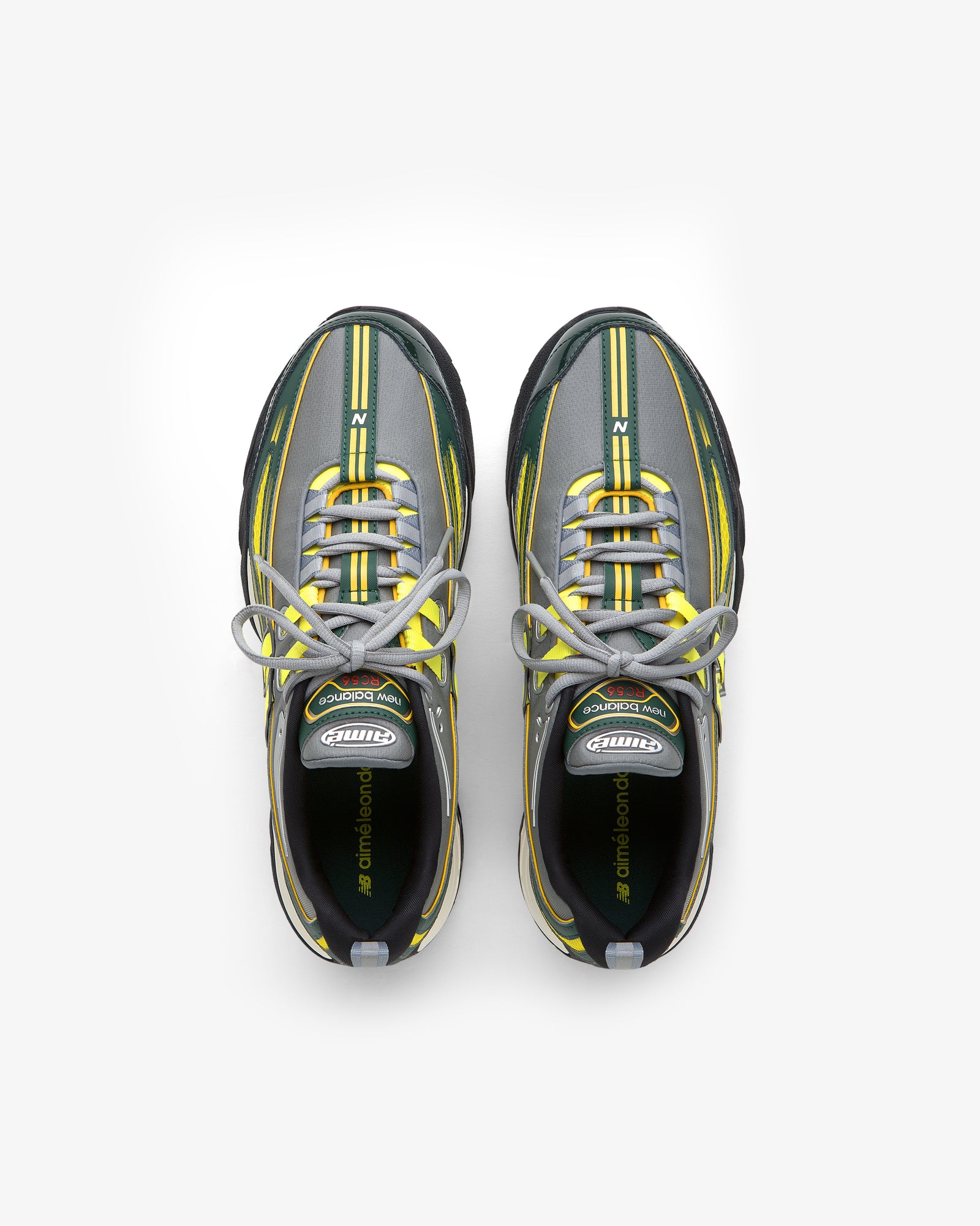The ALD / New Balance RC56 sneakers in gray, black, and yellow with white laces, seen from above on white.