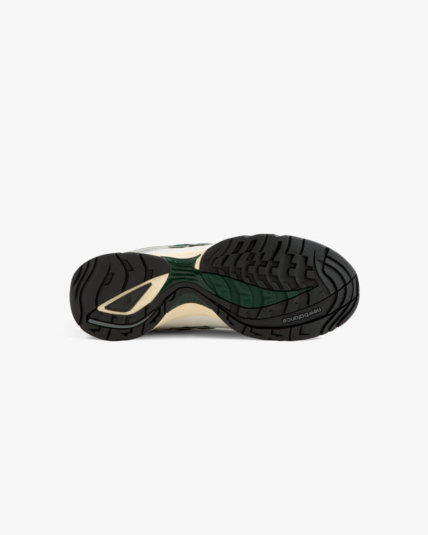 Bottom view of the ALD / New Balance RC56 sneaker showing a black, green, and beige rubber sole with patterned tread.