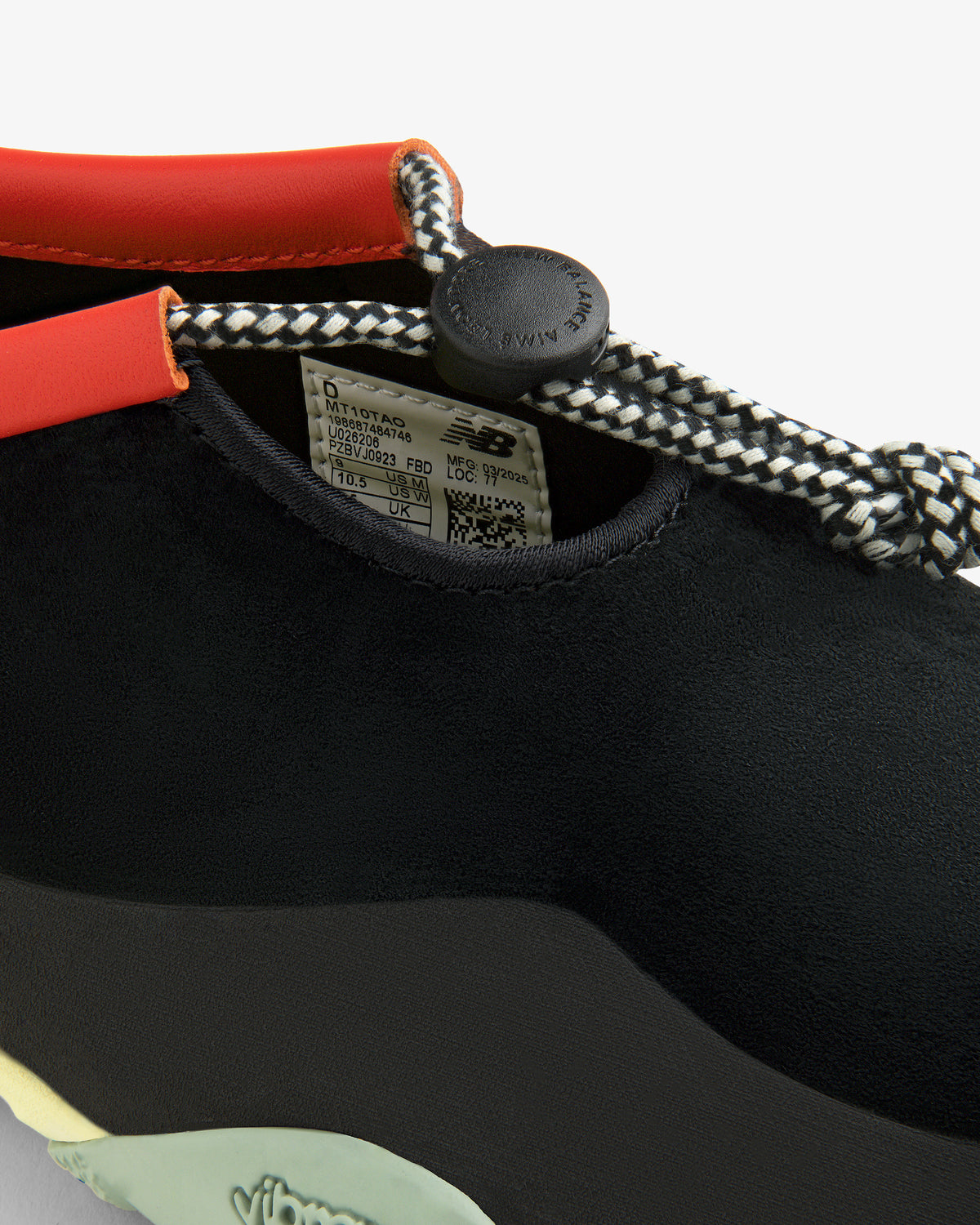 Close-up of the black ALD / New Balance MT10T Sport Shoe with patterned laces, orange trim, and Vibram branding.
