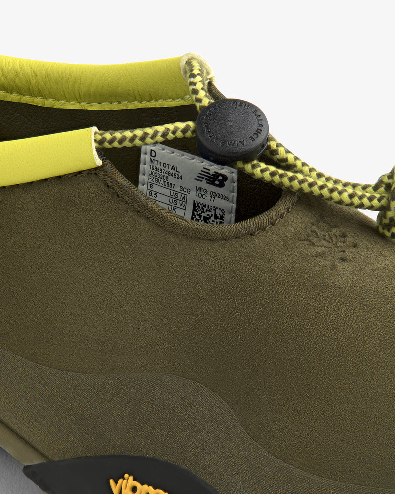 Close-up of the ALD / New Balance MT10T Sport Shoe in olive green with yellow lace, black toggle, and NB label inside.