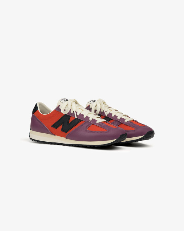 A pair of ALD / New Balance 471 sneakers in red, purple, and black with white laces on a white background.