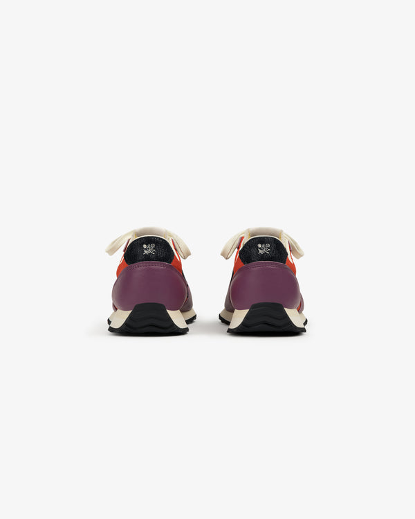 The ALD / New Balance 471 sneakers in purple and red, with white laces and black soles, shown from the back.
